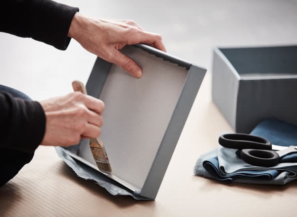 Alte Schuhkartons u. a. mit Meterware in Hellblau und alten Buchseiten bekleben, fertig ist die Aufbewahrung.