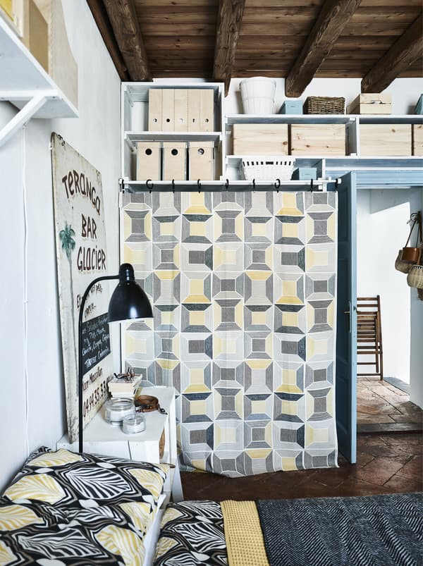 Amarelo gráfico, téxtiles en branco e negro nun dormitorio.
