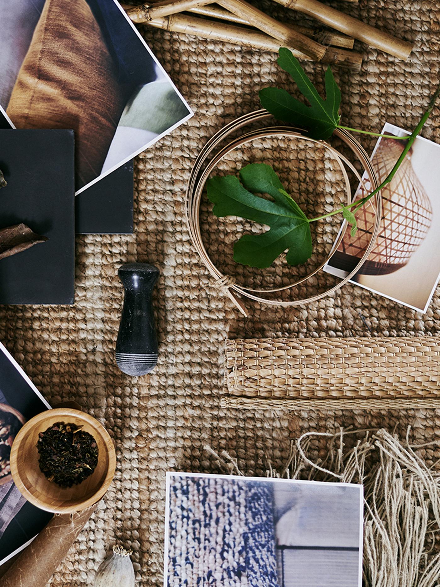 Ambal tenunan kasar dengan beberapa gambar bercetak serta pelbagai bahan mentah termasuk daun dan wul.
