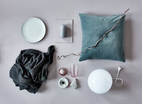 An aerial view of a cushion, blanket, a lamp and natural elements for fall decoration.