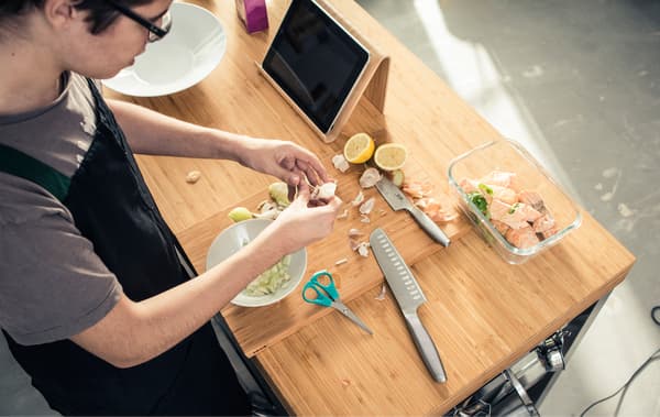 An aerial view of a teenager slicing garlic