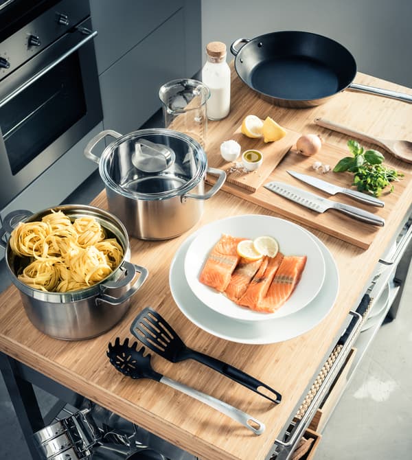 An aerial view of the ingredients and cooking tools needed to make a creamy salmon pasta.