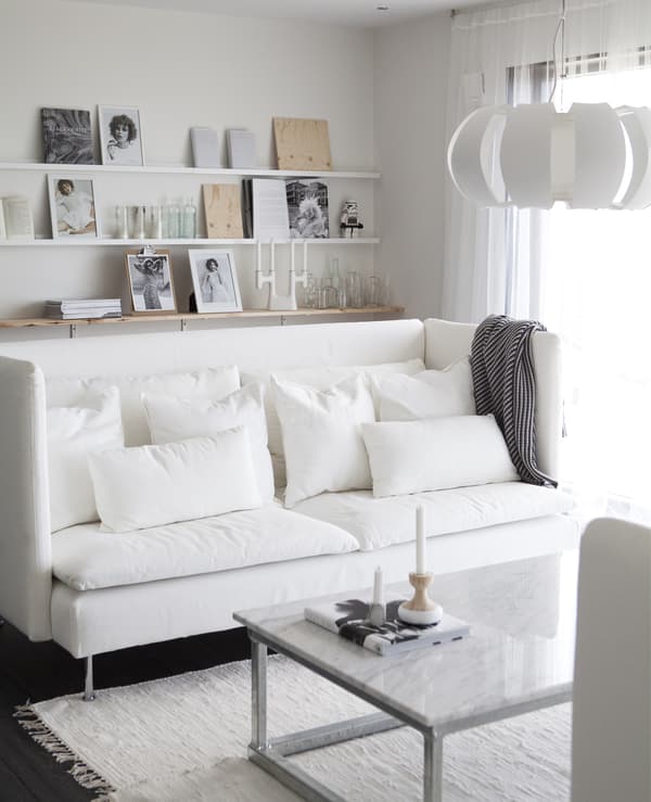 An all-white room with white sofa and textiles.