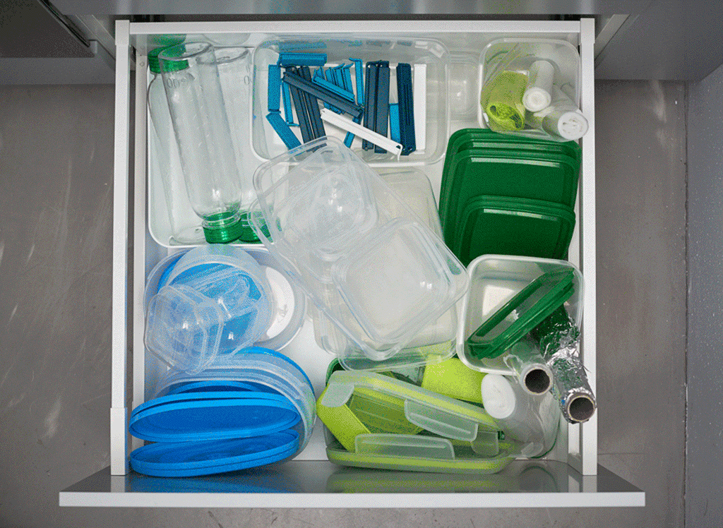 An animated GIF of organising a kitchen drawer full of plastic storage boxes, bottles, aluminium foil and more.