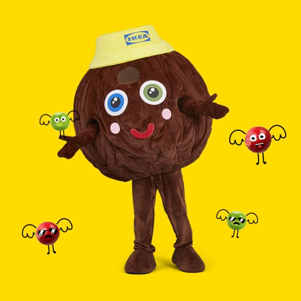 An animator dressed in a Meatball costume stands against a yellow background with arms stretched forward, as if inviting a hug. Around them, red and green bubbles with drawn faces are flying.