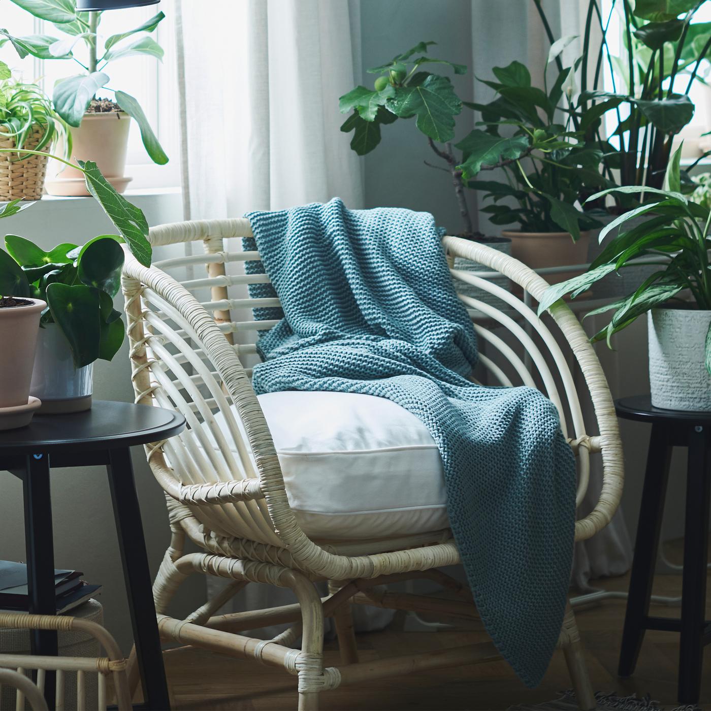 An area by a window becomes an oasis with plants in CHIAFRÖN and MUSKÖTBLOMMA pots, INGABRITTA throw and a rattan chair.
