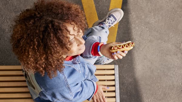 An arial view of a person holding a hot dog
