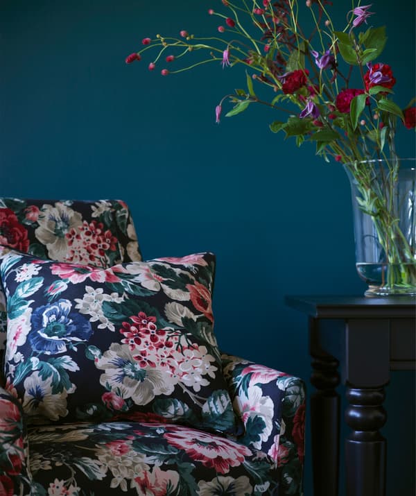 An arm chair with matching cushion in a bold floral pattern.