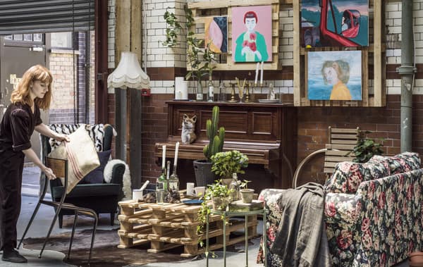 An armchair, cushion and throw in an industrial space.