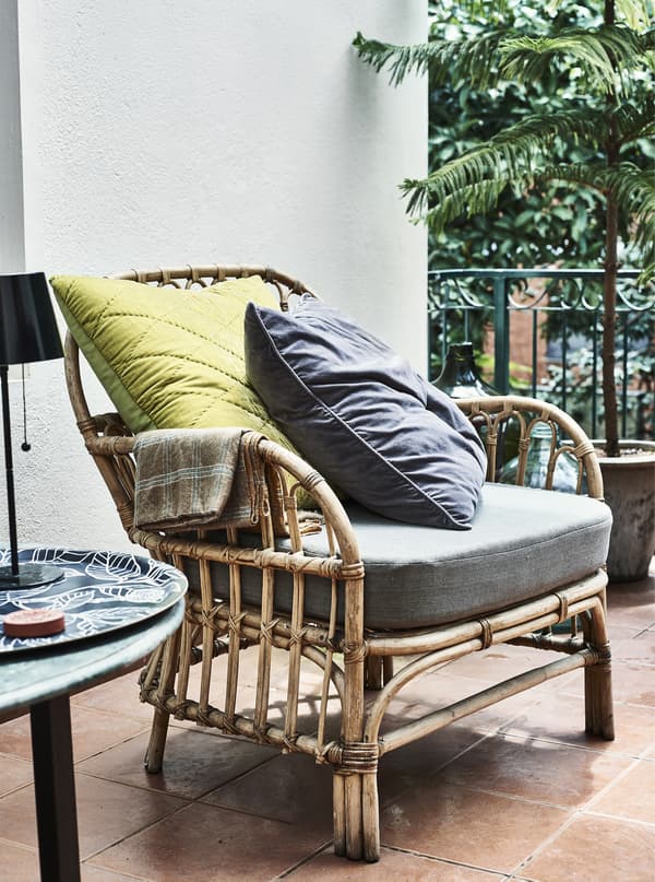 An armchair with cushions and a side table.