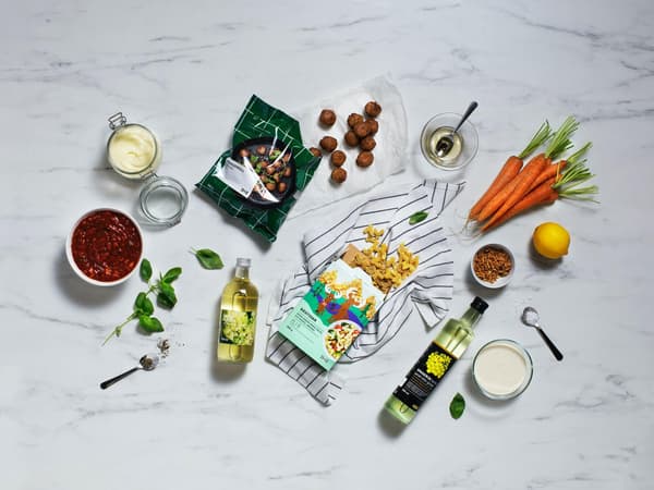 An assortment of plant based ingredients arranged around a package of plant balls and a bottle of cooking oil.