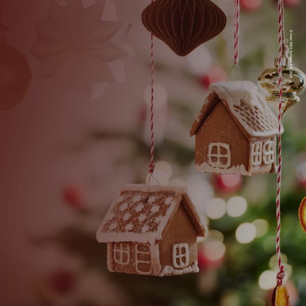 An Bändern befestigte,  winterlich verzierte Lebkuchenhäuser, die in der Luft schweben.