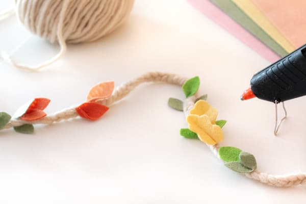 An einer Filzschnur wurden kleine Blätter aus Filz mit Heißkleber befestigt.