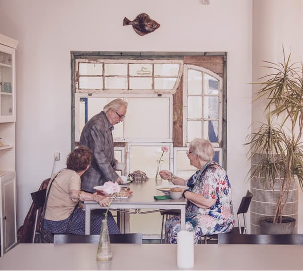 An elderly couple and a friend of theirs are having lunch together in an eclectic restaurant.