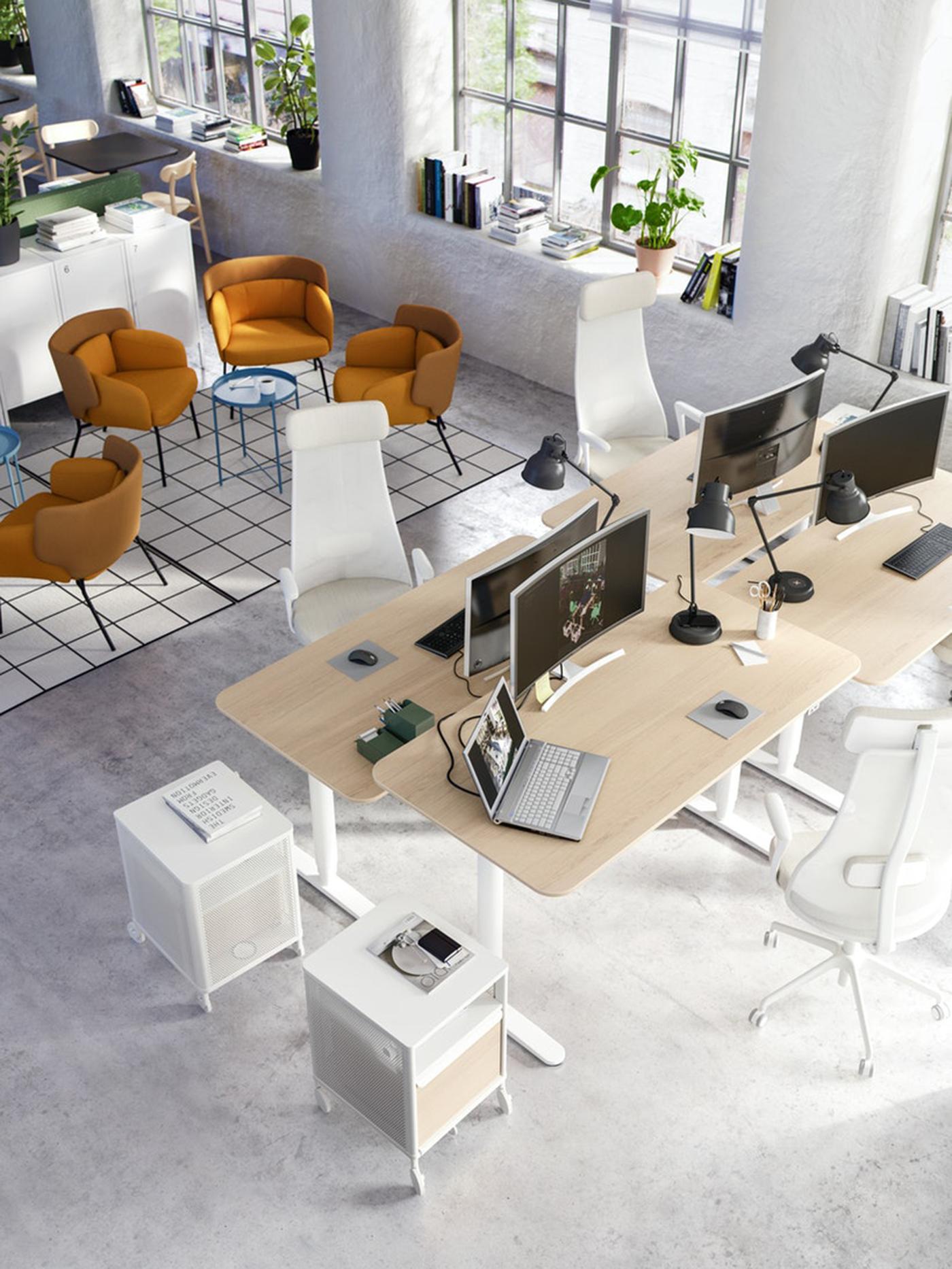 An empty office showing a long table with computer monitors.
