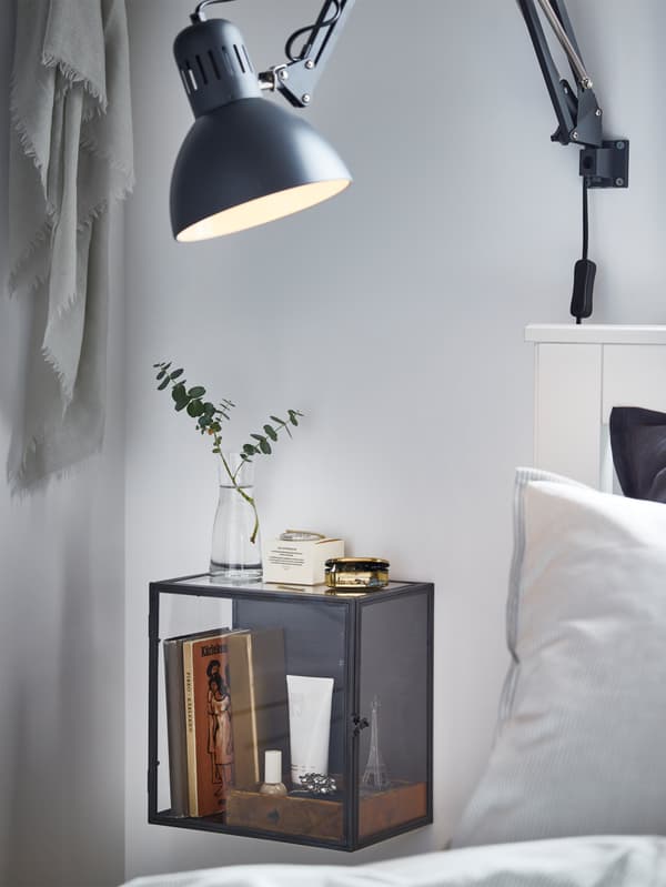 An IKEA BARKHYTTAN black display box, and a TERTIAL dark grey work lamp mounted on the wall.