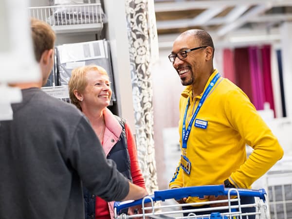 An IKEA co-worker assisting customers in store