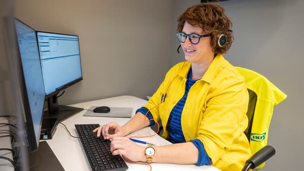 An IKEA co-worker dealing with a customer inquiry at an IKEA service desk.