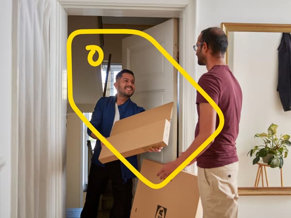 An IKEA co-worker delivering flat pack boxes to a customer's house.