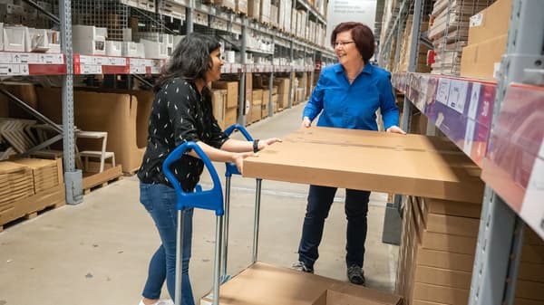 An IKEA co-worker helping a customer take a box of furniture at the self-pick up area.