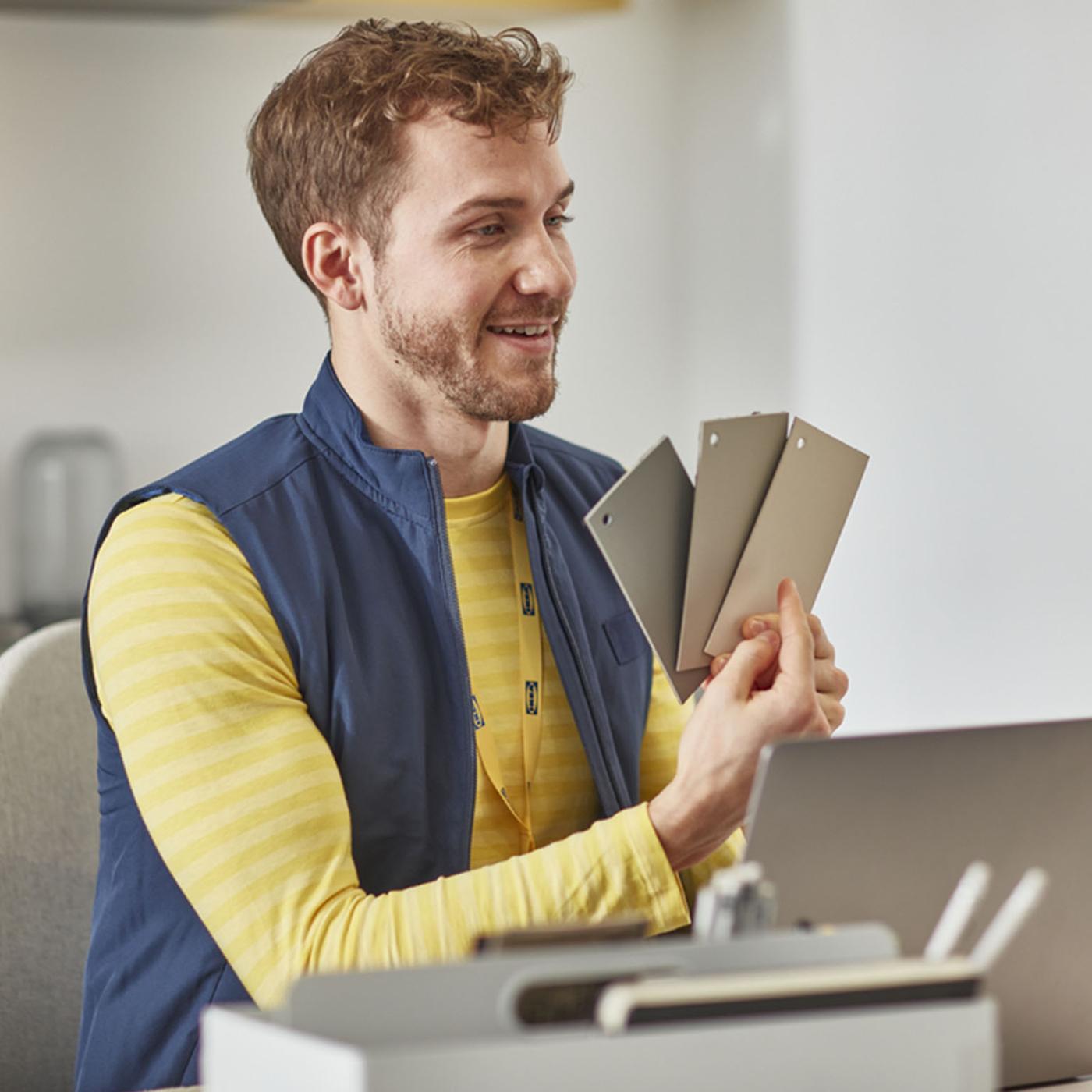 An IKEA co-worker holding three tiles.