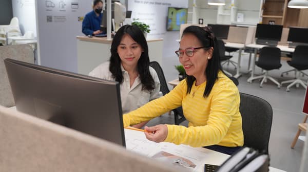 An IKEA co-worker is attending to a customer in the store