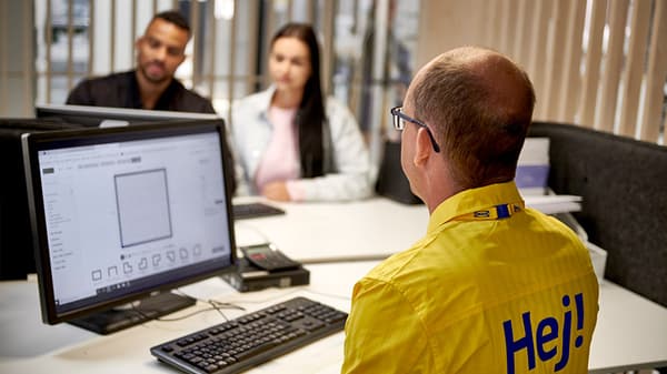 An IKEA co-worker is helping a couple plan a bathroom at an in-store planning appointment.