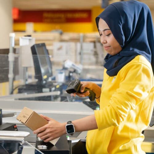 An IKEA co-worker is scanning a product for the customer.