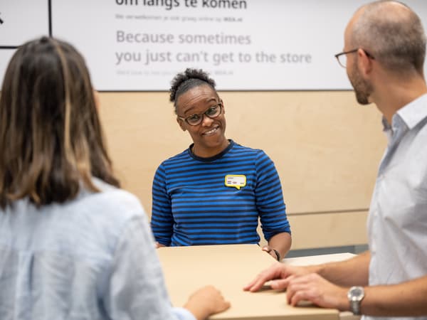 An IKEA co-worker processing a return for two customers