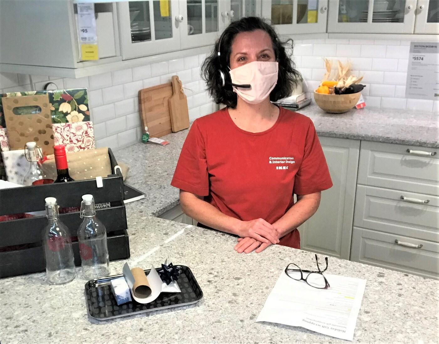 An IKEA Co-worker smiling with a headset and Holiday decorations around her, ready to hold a workshop