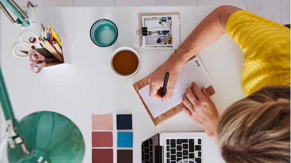 An IKEA co-worker takes notes in a notebook.