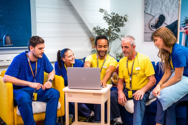 An IKEA co-worker wearing a yellow uniform with the word “Hej!” on the back of the shirt.