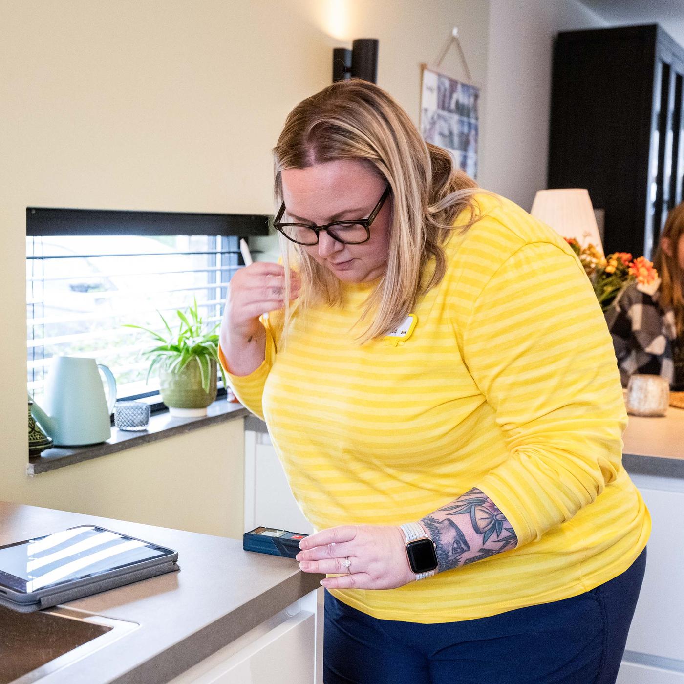 An IKEA coworker measuring a customers kitchen area in their home