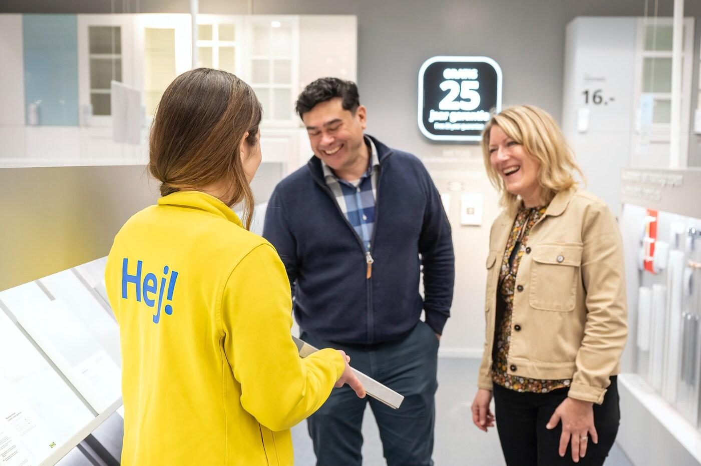 An IKEA coworker showing a couple some kitchen samples in the store kitchen planning area