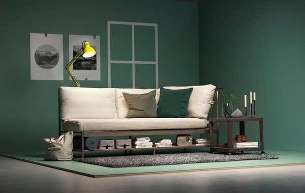 An IKEA EKEBOL sofa, TINGBY side table and TERTIAL lamp in a staged living room setting with green walls and floor.