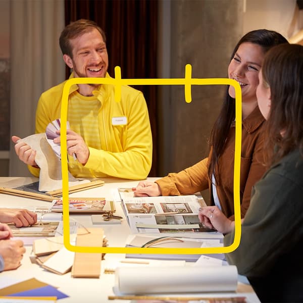 An IKEA employee and two women at a table planning, above them an IKEA illustration of a calendar