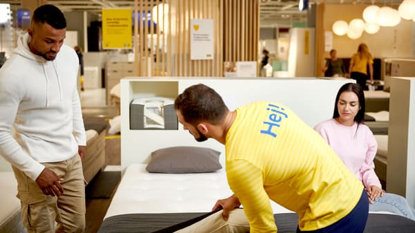 An IKEA employee is seen helping a couple pick out a mattress at the IKEA store.