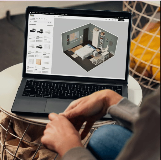 An IKEA employee sits on front of a screen with a headset on