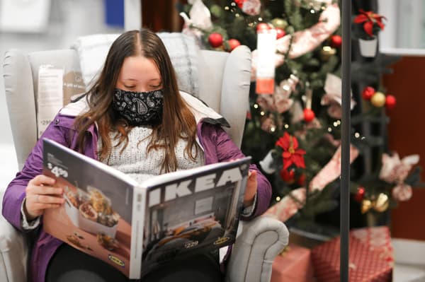 An IKEA Family member holding her IKEA Coffee Table Catalogue