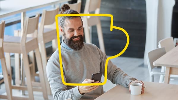 An IKEA Family member is sitting in the restaurant drinking a cup of coffee.