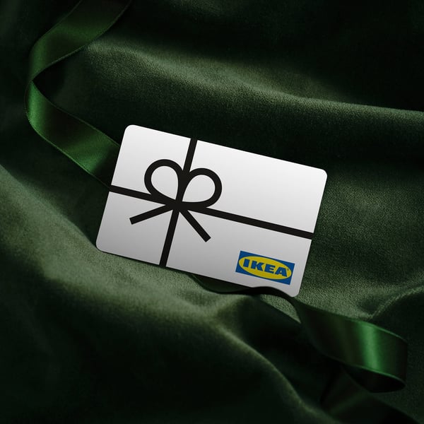 An IKEA gift card relaxing on a beautiful, soft bed of green fabric.