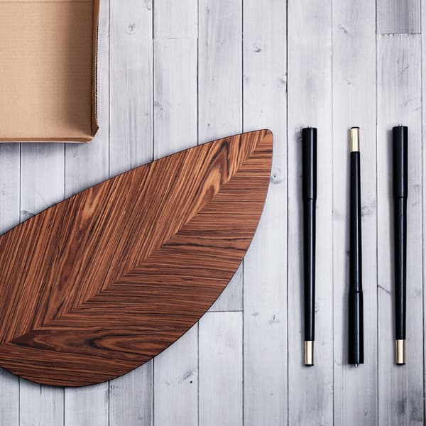 An IKEA LÖVBACKEN table, disassembled in its four parts, laying on a white wood flooring.