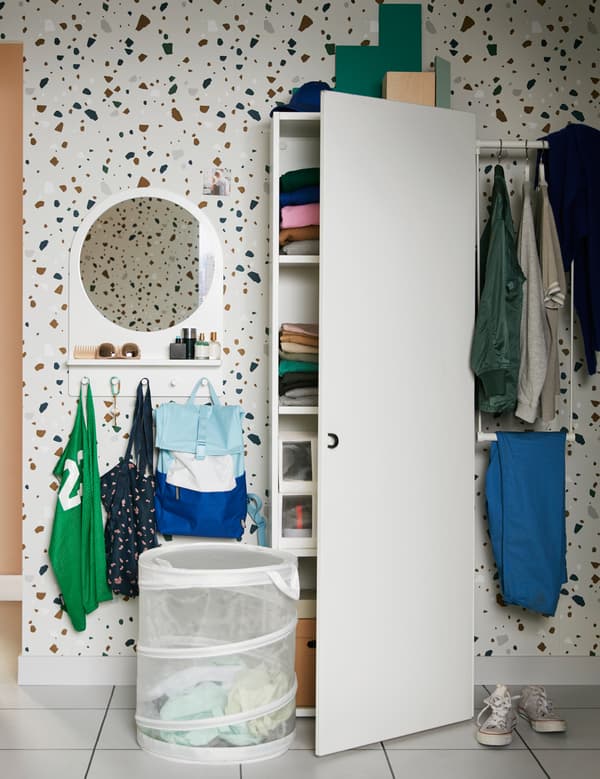 An IKEA PLATSA white wardrobe and a white mesh FYLLEN laundry basket in a teen bedroom.