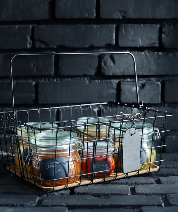An IKEA PLEJA wire basket filled with jars of home made goodness.