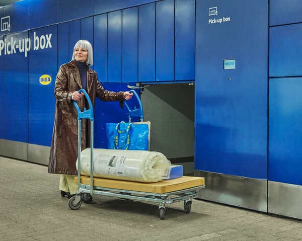 An ikea shopper picking up their order from a locker with a trolley