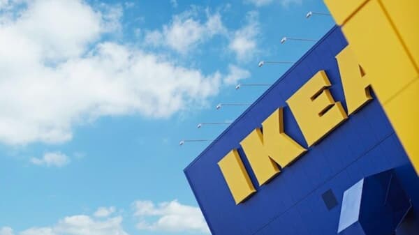 An IKEA storefront with the IKEA lettering against a blue sky with white clouds.