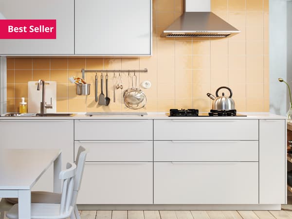 An IKEA VEDDINGE white kitchen with wooden worktop and handles on doors and drawers.