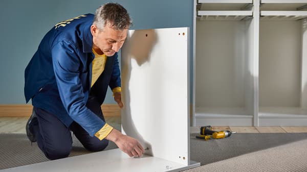 An IKEA worked inctalling a kitchen cabinet