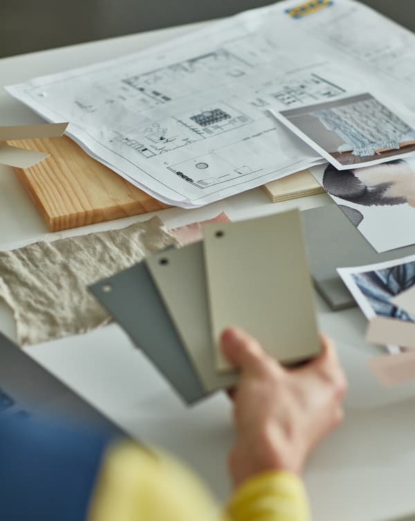 An IKEA worker showing differente colours to choose for an interior design.