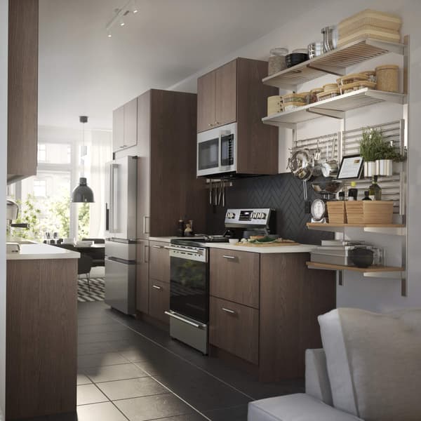 An image of a modern, well-lit kitchen with brown wooden cabinets and a white countertop.